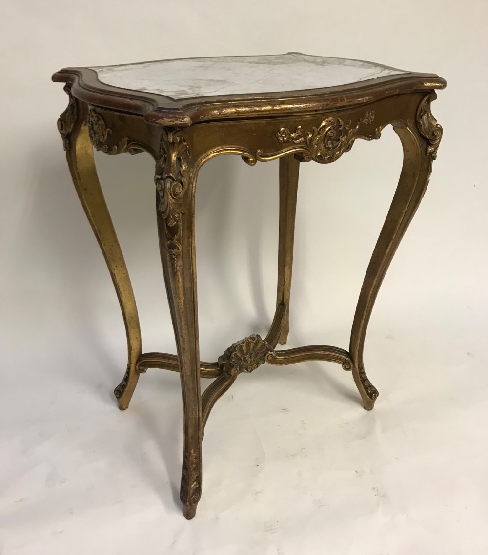 A French Louis XV style giltwood side table featuring a contoured white marble top, carved cabriole legs, and an X-shaped stretcher with a central shell motif. View VI