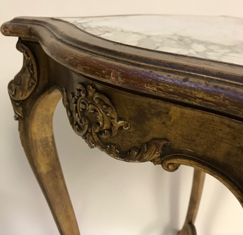 A French Louis XV style giltwood side table featuring a contoured white marble top, carved cabriole legs, and an X-shaped stretcher with a central shell motif. View VIII