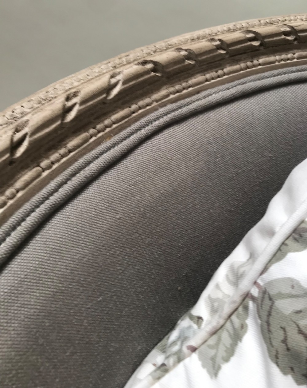 A French Louis XVI style upholstered daybed featuring a carved taupe-grey timber frame, fluted legs, a grey cushion seat, and a floral accent pillow. View VIII