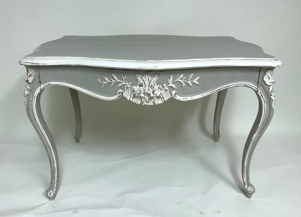 A grey painted French Rococo style side table featuring carved white foliate accents and slender cabriole legs. View II