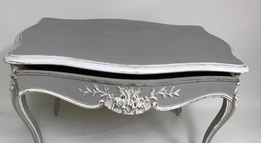 A grey painted French Rococo style side table featuring carved white foliate accents and slender cabriole legs. View III