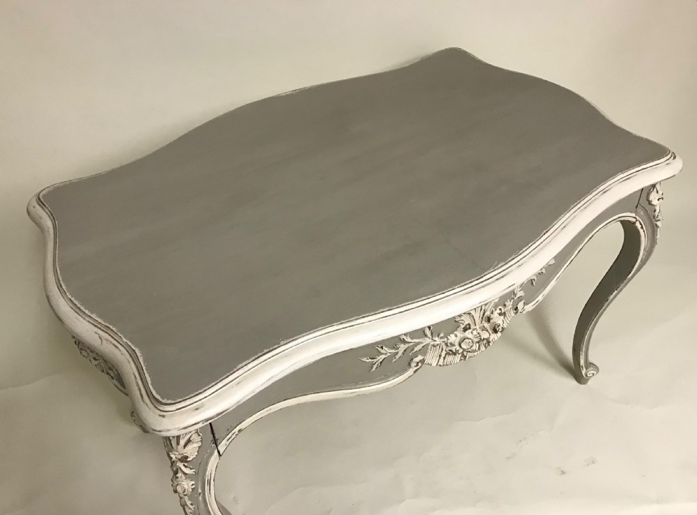 A grey painted French Rococo style side table featuring carved white foliate accents and slender cabriole legs. View VIII