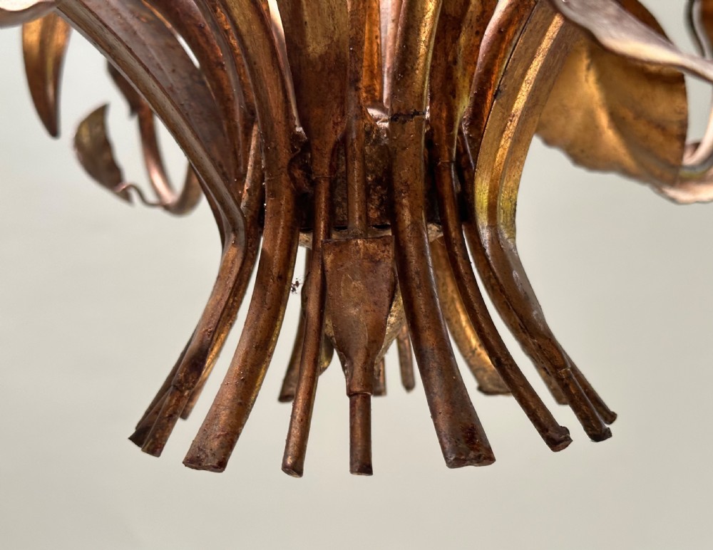 A French gilt metal multi-arm ceiling chandelier featuring sculptured flower petals, leaf motifs, and six candle-style light sockets. View VII