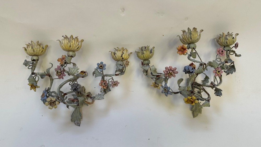 A pair of French floral wall sconces constructed from painted metal with branching foliate arms and colourful tulip-shaped sockets.