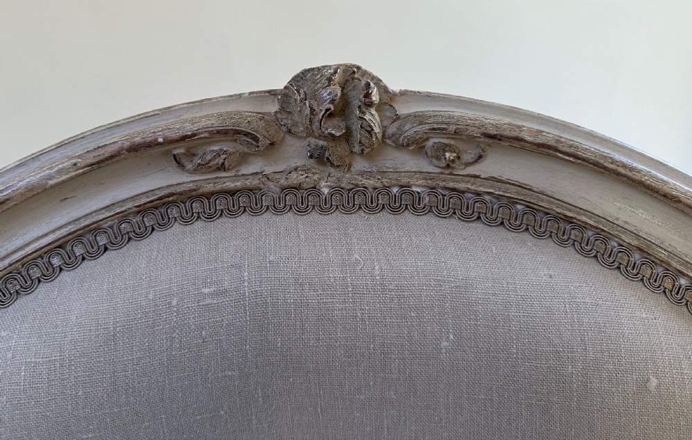A pair of French Louis XV style open armchairs with grey painted carved wooden frames and neutral linen upholstery. View VI