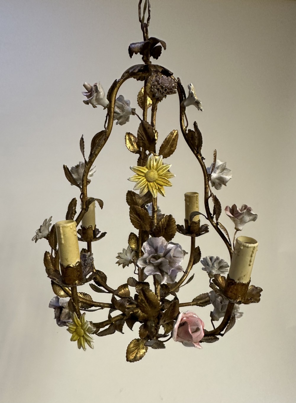 A French gilt metal cage chandelier decorated with multicoloured porcelain flowers and leaf motifs.