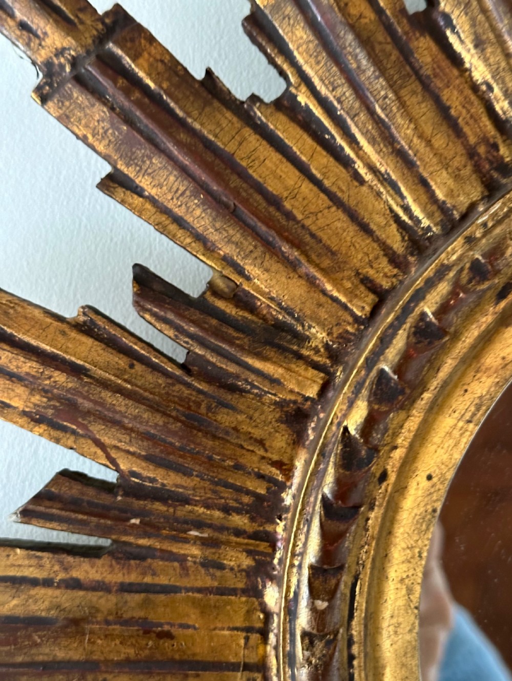 A circular wall mirror set within a gilded wooden frame featuring radiating, multi-tiered sunburst rays. View IV