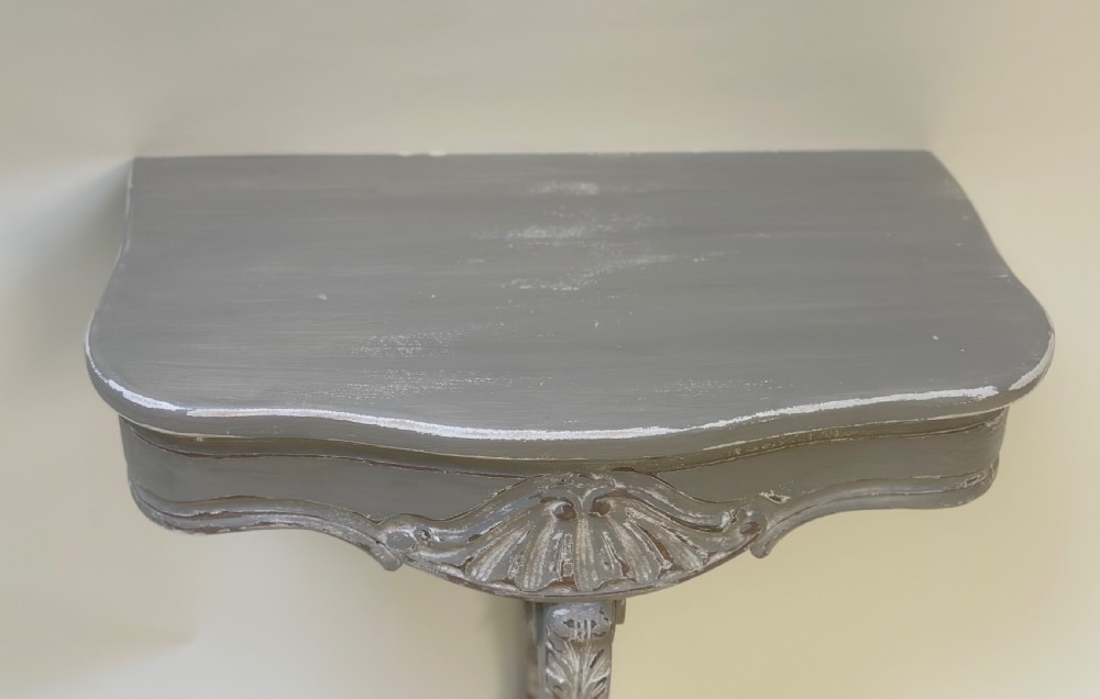 A pair of distressed grey painted French wall-mounted console tables featuring carved scallop shell motifs and single scrolled legs. View III