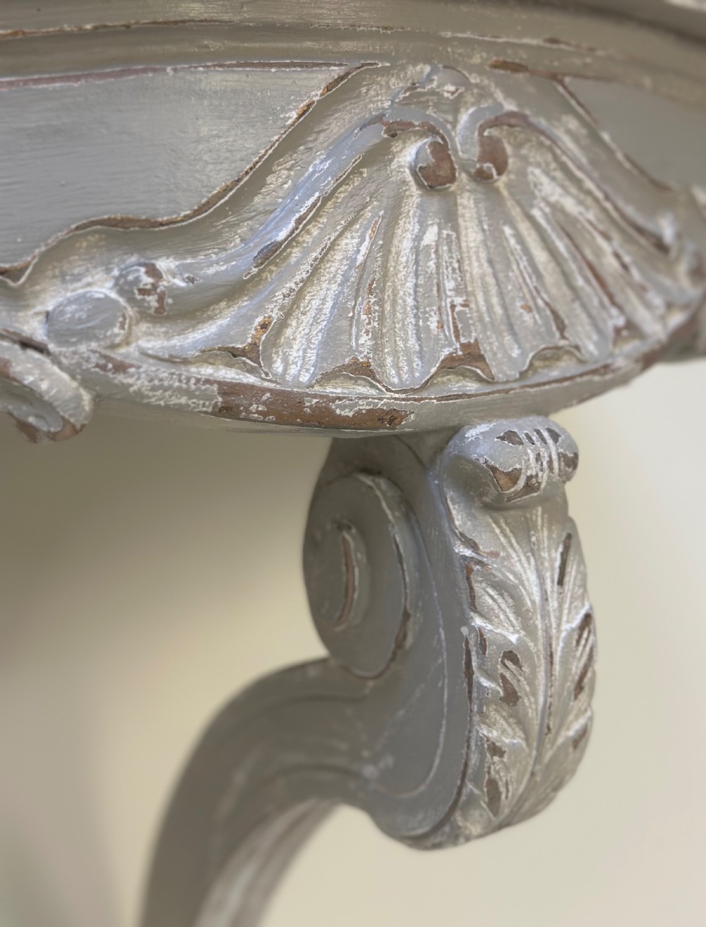 A pair of distressed grey painted French wall-mounted console tables featuring carved scallop shell motifs and single scrolled legs. View IV
