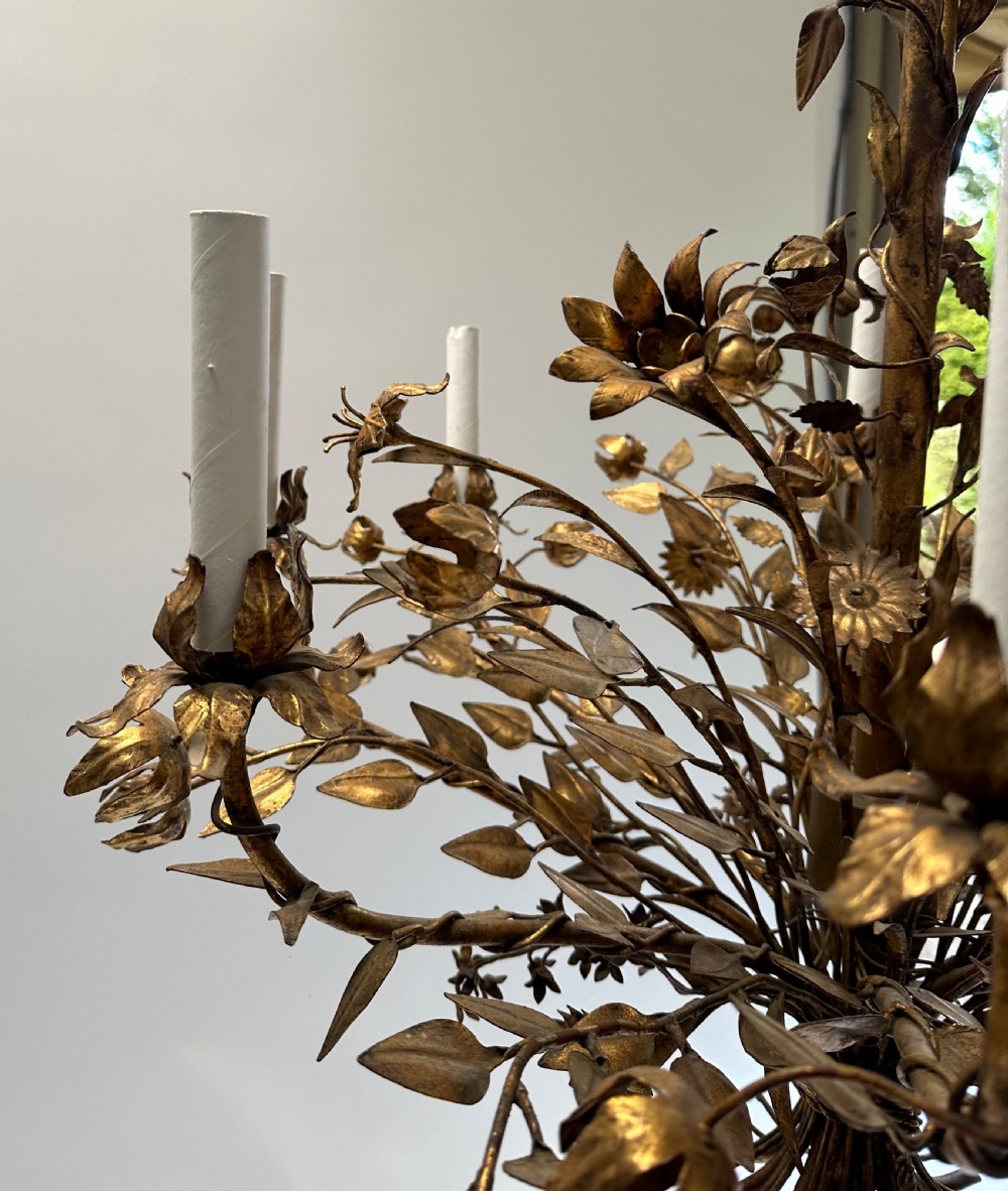 A multi-arm gilt metal chandelier featuring hand-worked botanical leaves, stems, flowers, and white tubular candle sleeves. View II