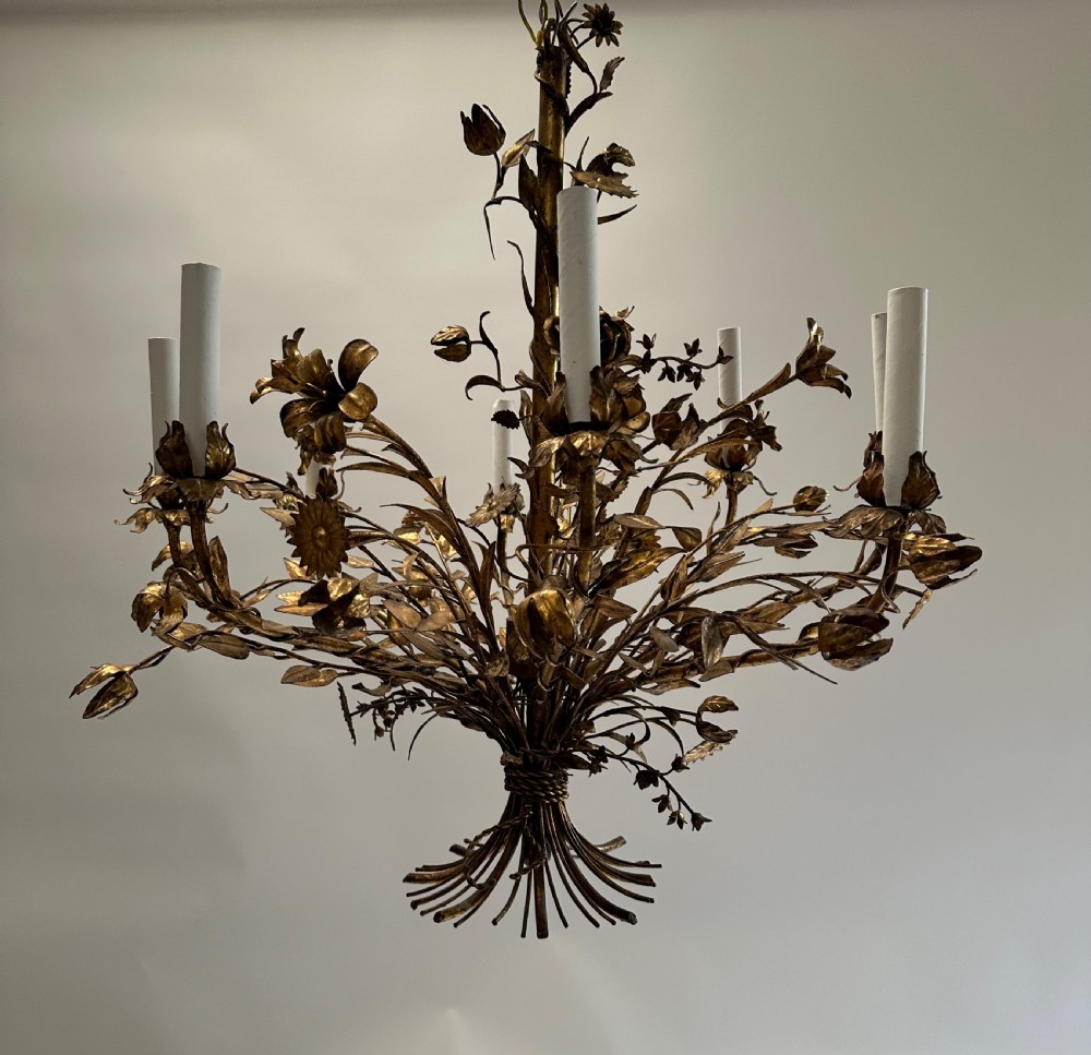 A multi-arm gilt metal chandelier featuring hand-worked botanical leaves, stems, flowers, and white tubular candle sleeves. View III