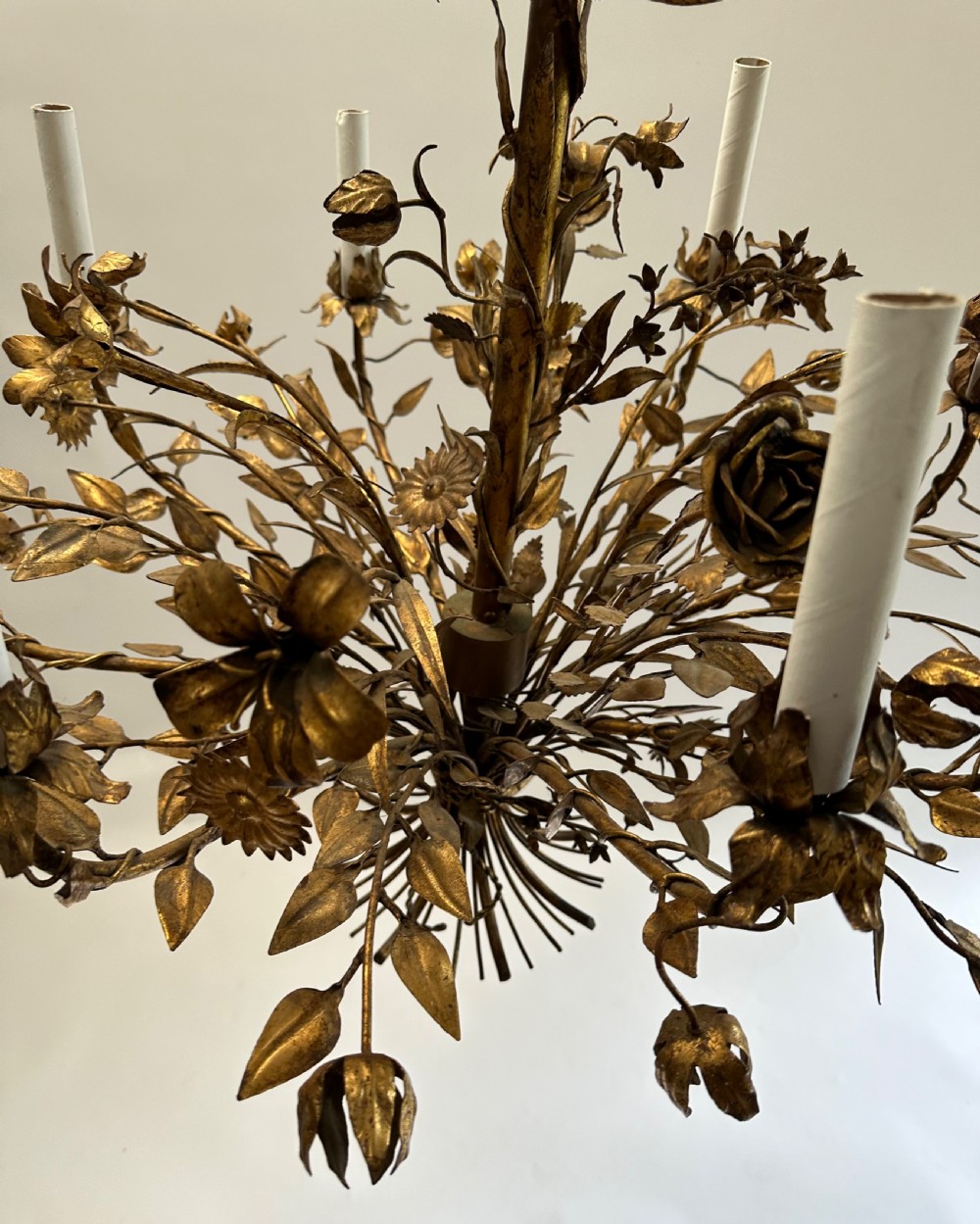 A multi-arm gilt metal chandelier featuring hand-worked botanical leaves, stems, flowers, and white tubular candle sleeves. View VIII