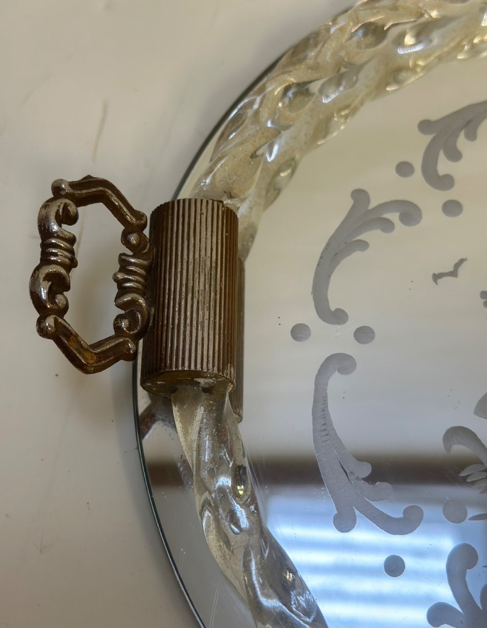 A circular Murano glass tray featuring a mirrored surface with an etched Venetian figure scene, framed by a twisted clear glass rim and two metal handles. View III