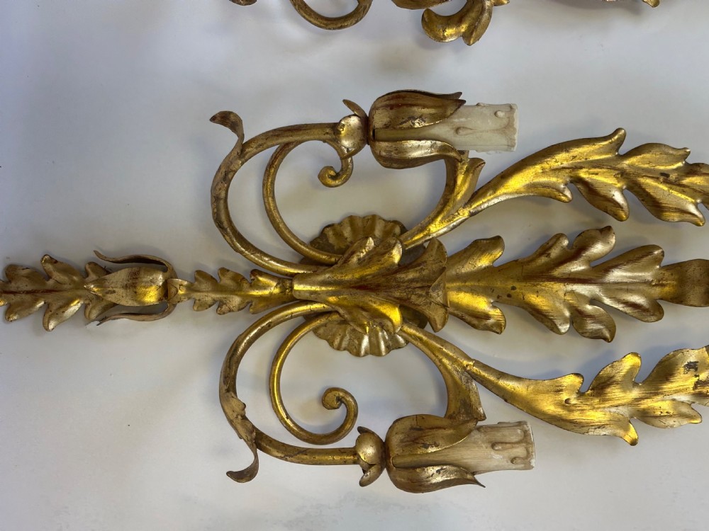 A set of four French gilded metal two-light wall sconces featuring scrolled acanthus leaf backplates and candle-style sconce arms. View III