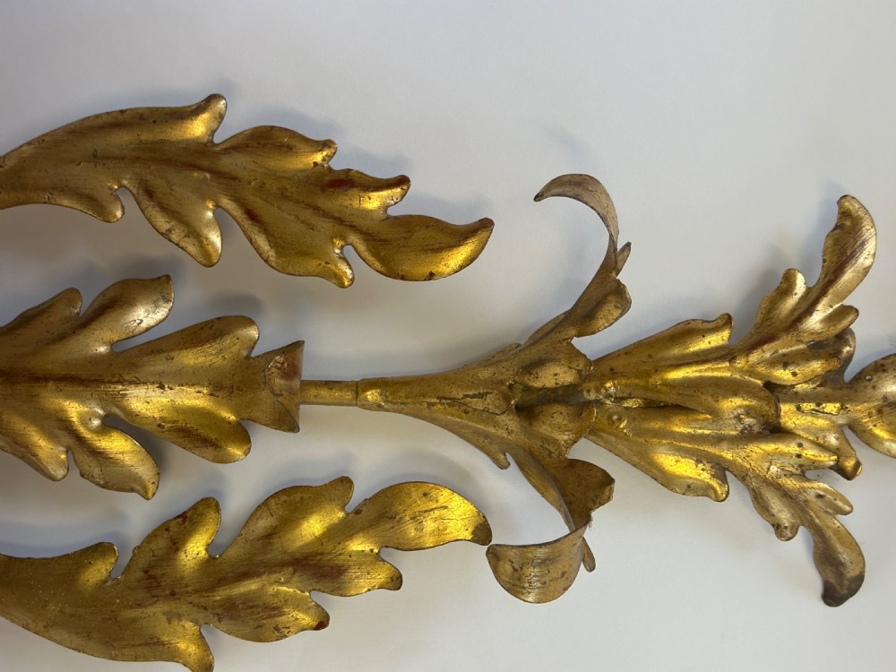 A set of four French gilded metal two-light wall sconces featuring scrolled acanthus leaf backplates and candle-style sconce arms. View V