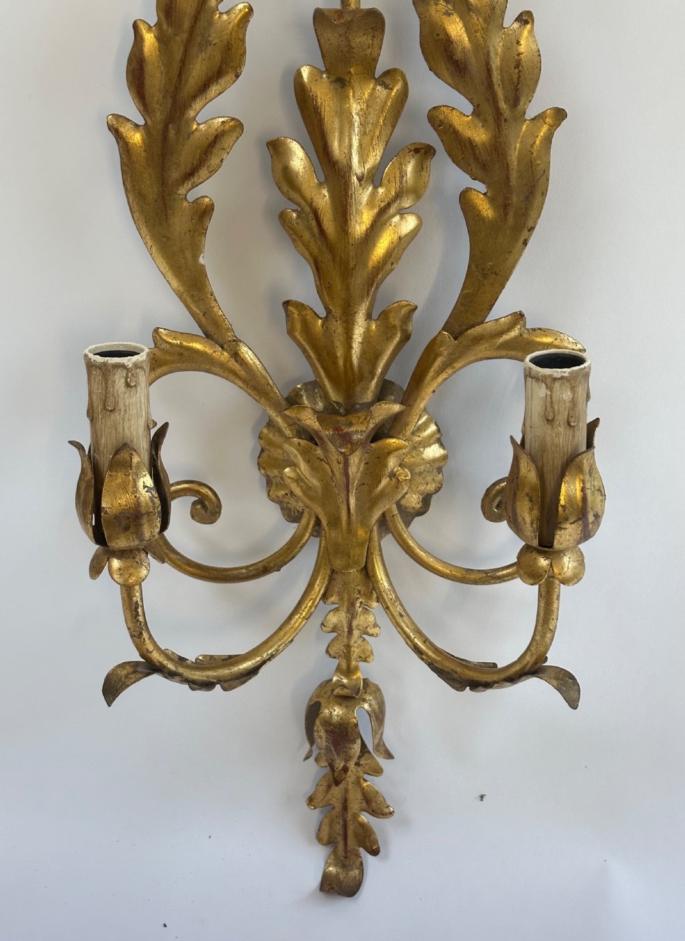 A set of four French gilded metal two-light wall sconces featuring scrolled acanthus leaf backplates and candle-style sconce arms. View IX