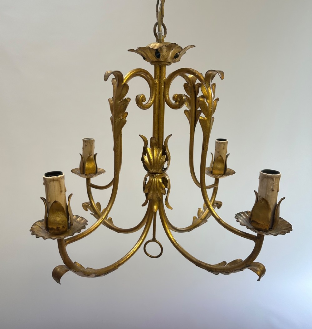A French gilded metal chandelier featuring four curved foliate arms, leaf motifs, central leaf decorations, and candle-style bulb holders. View IV