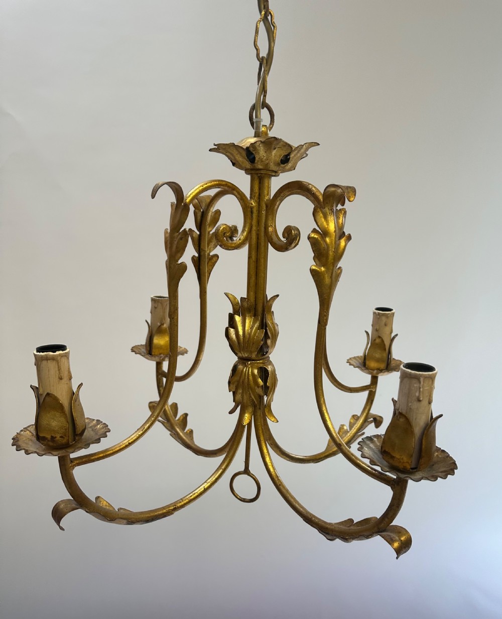 A French gilded metal chandelier featuring four curved foliate arms, leaf motifs, central leaf decorations, and candle-style bulb holders. View V