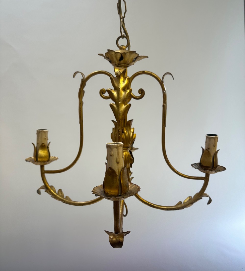 A French gilded metal chandelier featuring four curved foliate arms, leaf motifs, central leaf decorations, and candle-style bulb holders. View VI