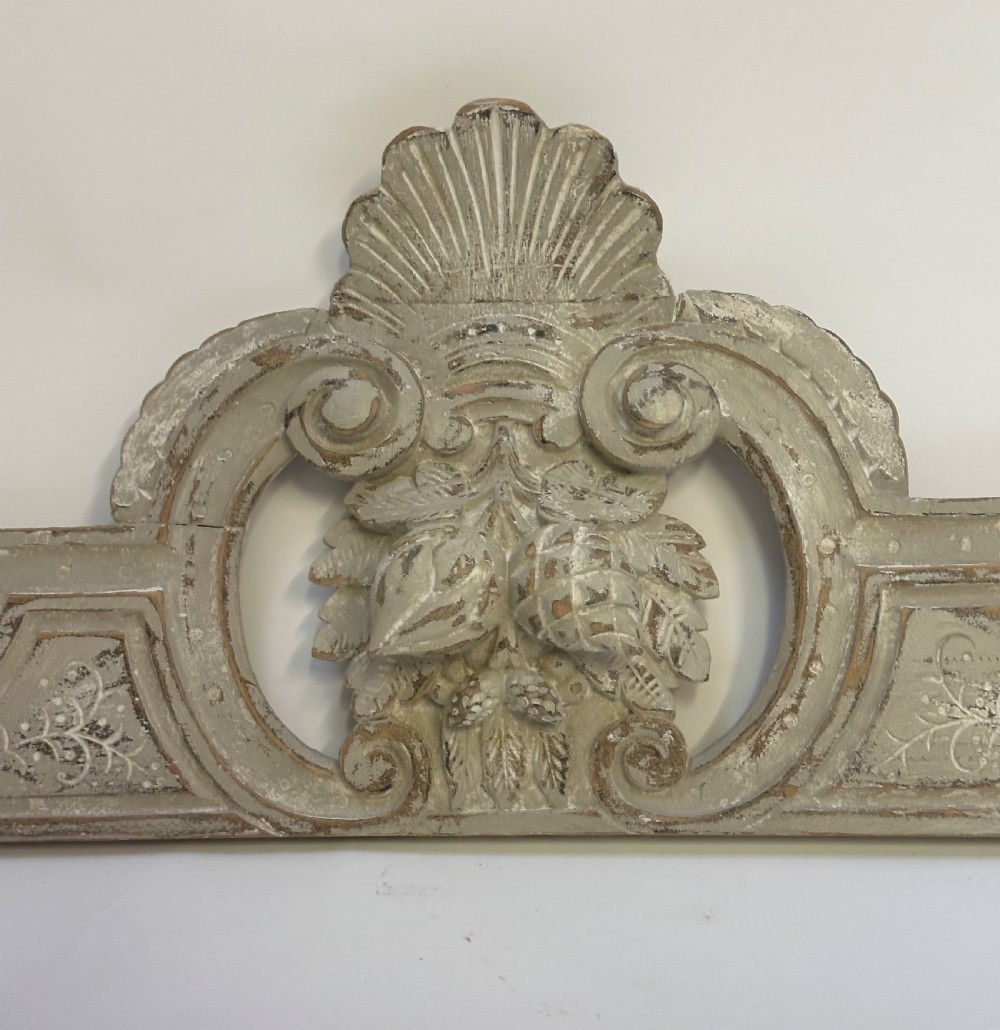 An antique French grey painted wooden pelmet featuring central hand-carved foliage and detailed scrollwork. View II