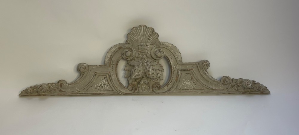 An antique French grey painted wooden pelmet featuring central hand-carved foliage and detailed scrollwork. View III