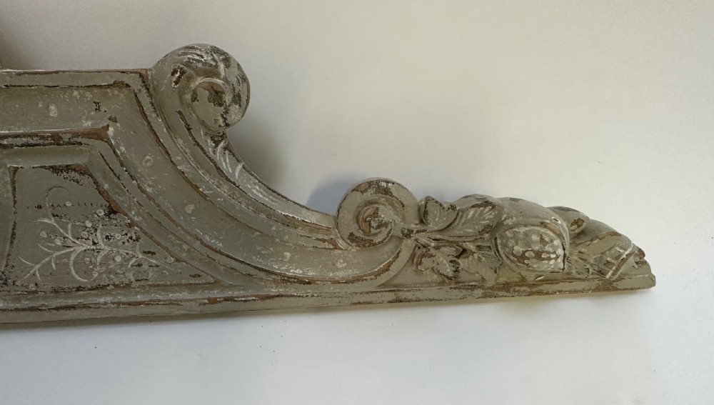 An antique French grey painted wooden pelmet featuring central hand-carved foliage and detailed scrollwork. View IV