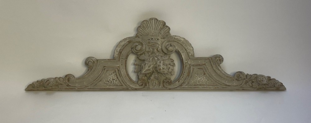 An antique French grey painted wooden pelmet featuring central hand-carved foliage and detailed scrollwork. View V