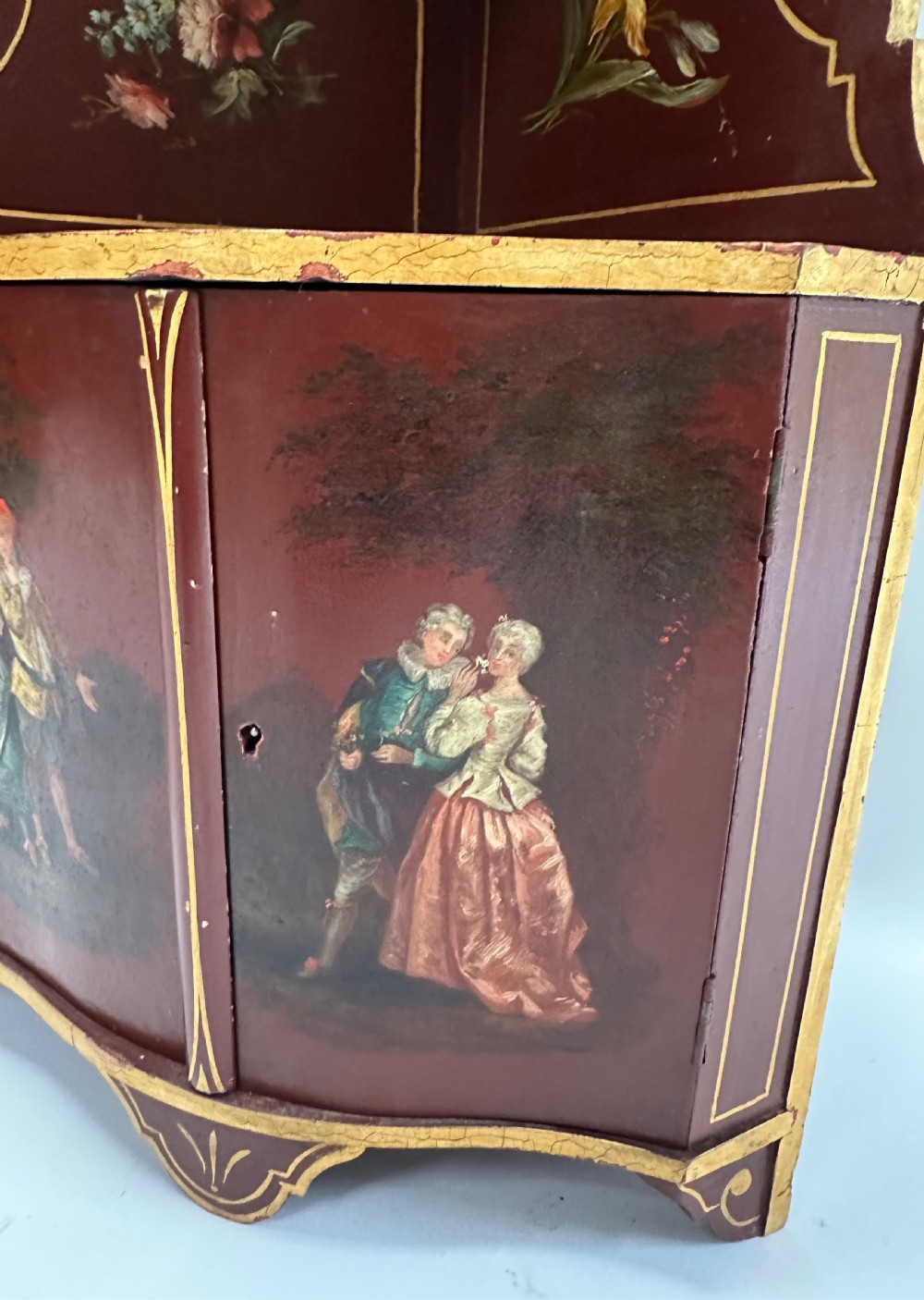 A matching pair of deep burgundy and gold painted Italian corner cupboards with upper open shelves and lower cabinet doors featuring hand-painted figures. View VII