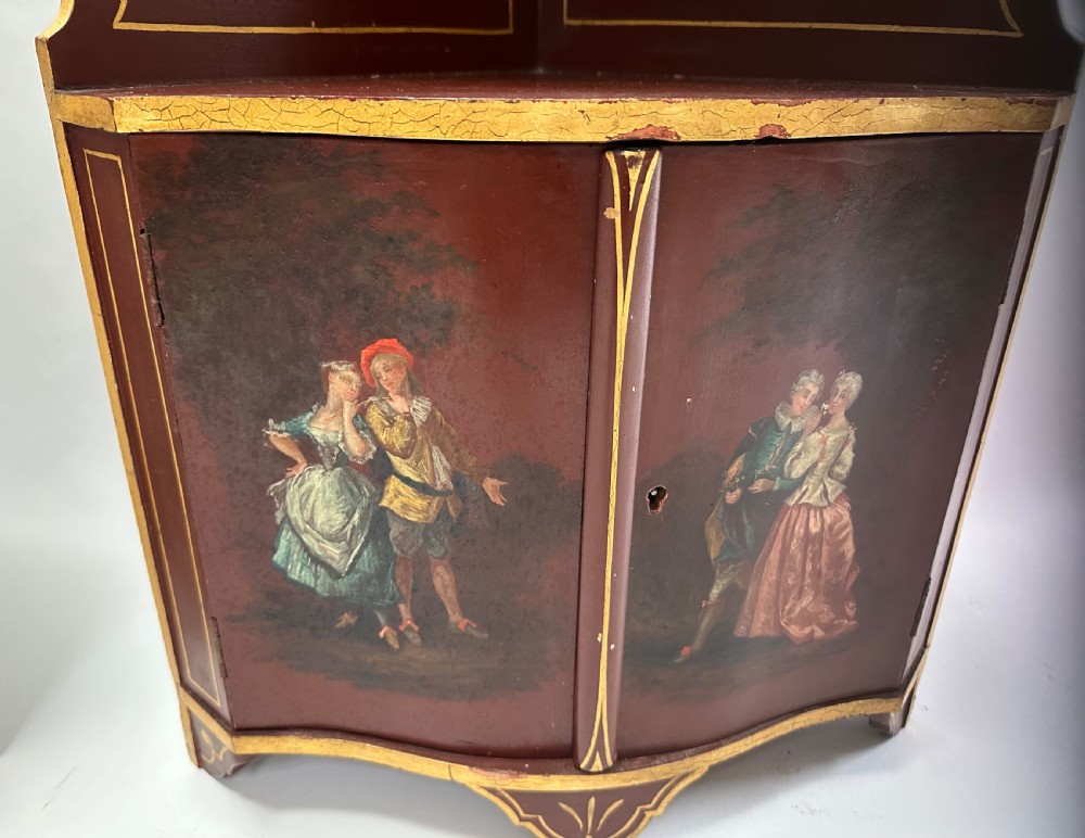 A matching pair of deep burgundy and gold painted Italian corner cupboards with upper open shelves and lower cabinet doors featuring hand-painted figures. View IX