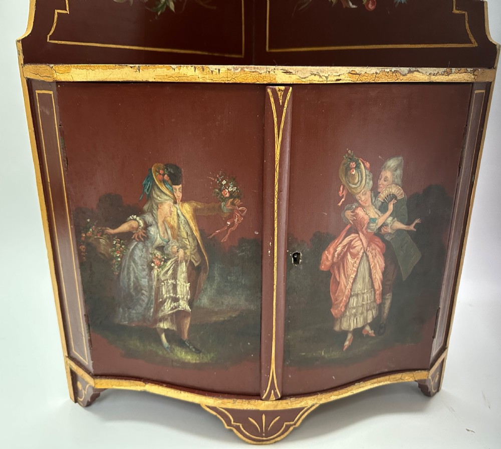 A matching pair of deep burgundy and gold painted Italian corner cupboards with upper open shelves and lower cabinet doors featuring hand-painted figures. View X