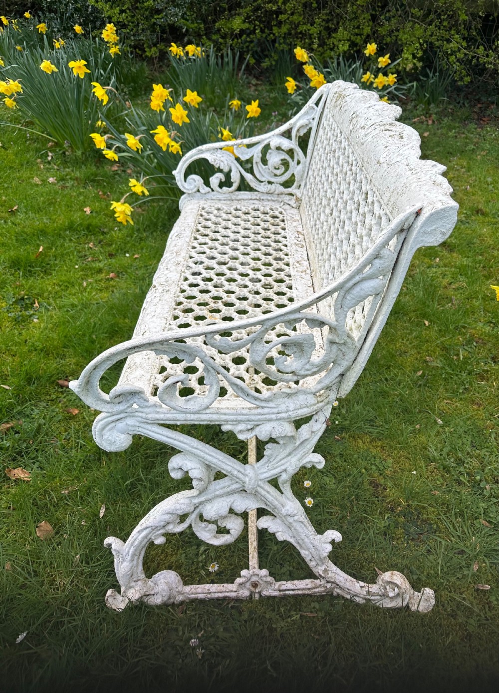 A Victorian white painted cast iron garden bench featuring a pierced lattice backrest and ornate scrolled armrests. View VI