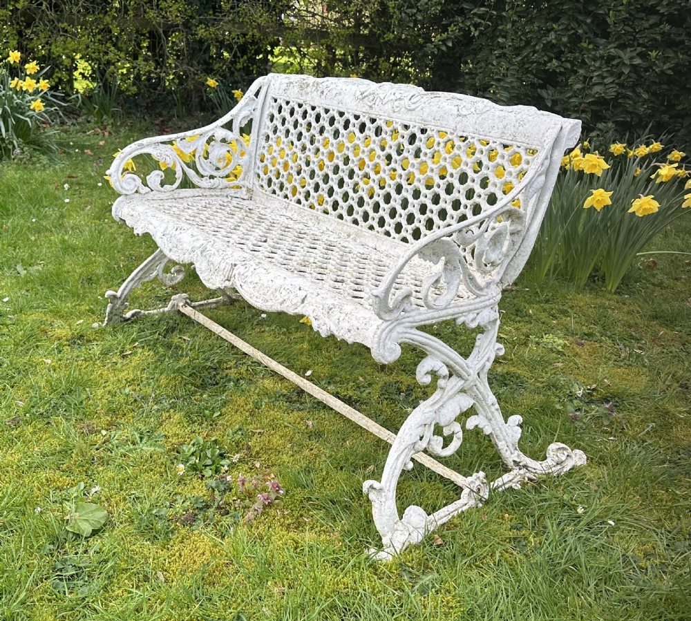 A Victorian white painted cast iron garden bench featuring a pierced lattice backrest and ornate scrolled armrests. View VIII