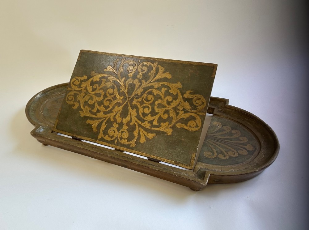 An antique Florentine painted and giltwood tabletop book stand with an open book resting on its angled surface. View II