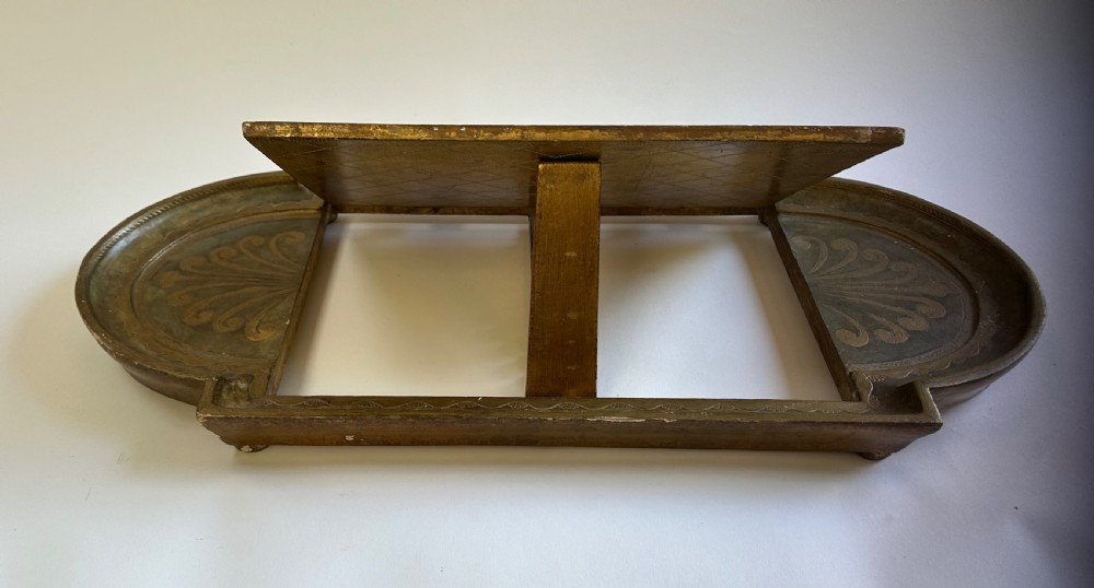 An antique Florentine painted and giltwood tabletop book stand with an open book resting on its angled surface. View VII