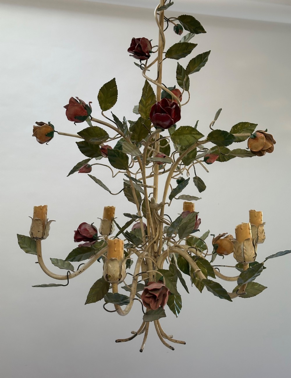 A French painted metal chandelier featuring dark green leaves, red rose blossoms, and cream candle-style lamp holders. View IX