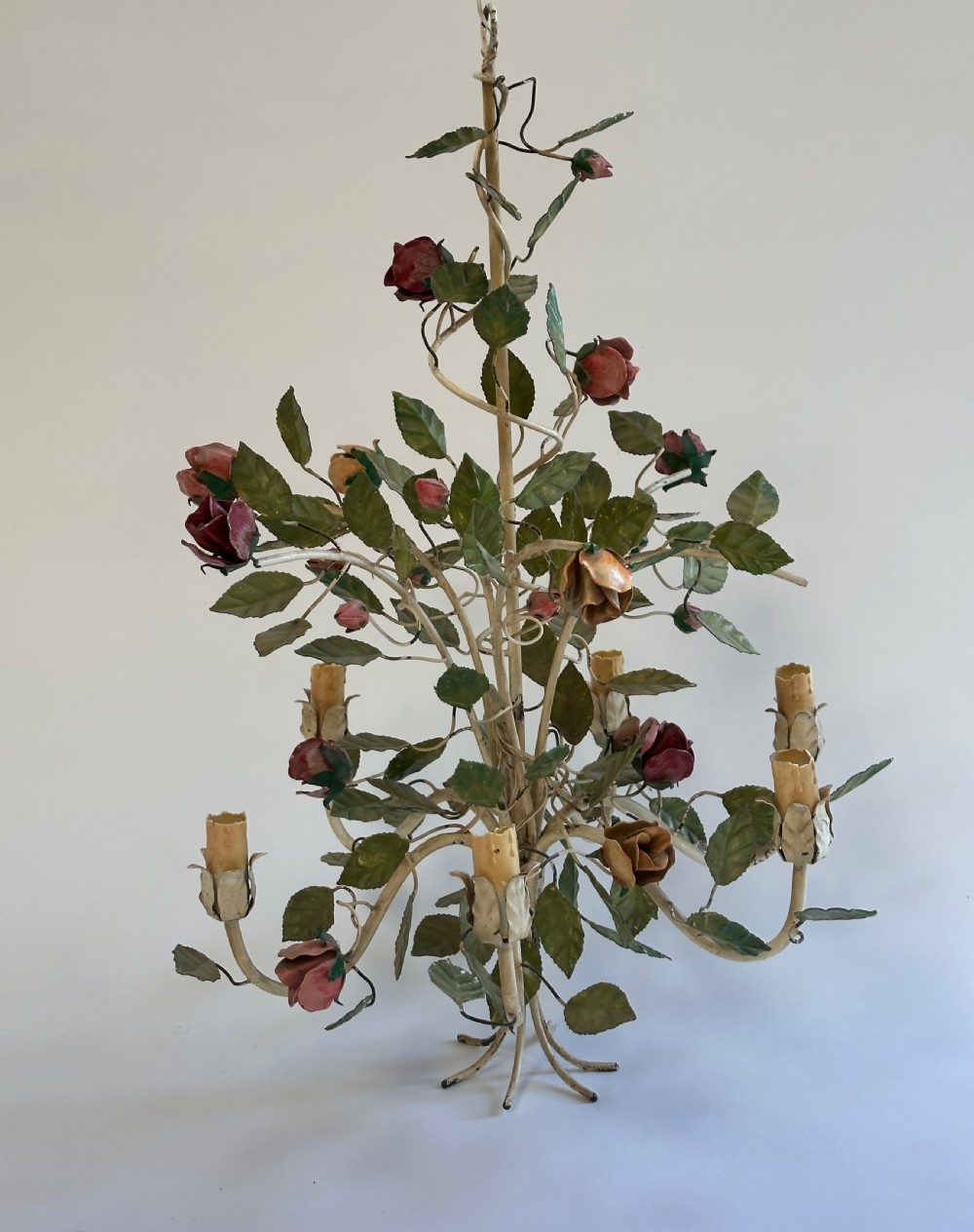 A French painted metal chandelier featuring dark green leaves, red rose blossoms, and cream candle-style lamp holders. View X