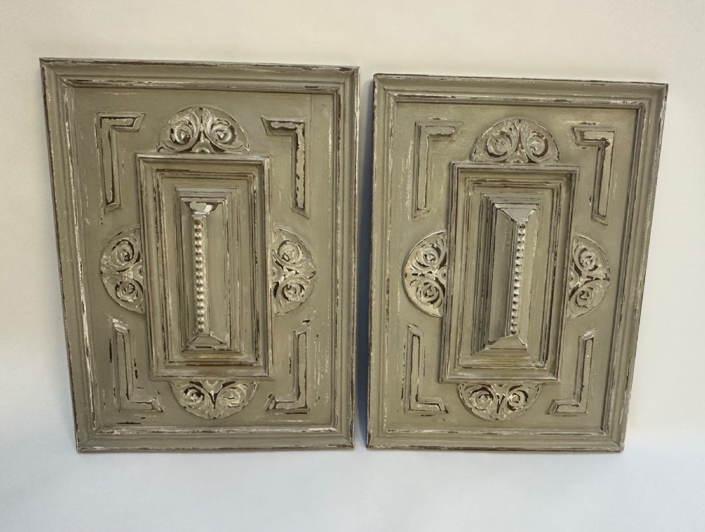 A pair of rectangular French hand-carved wooden panels featuring raised geometric mouldings, relief scrolls, and a distressed grey painted finish. View II