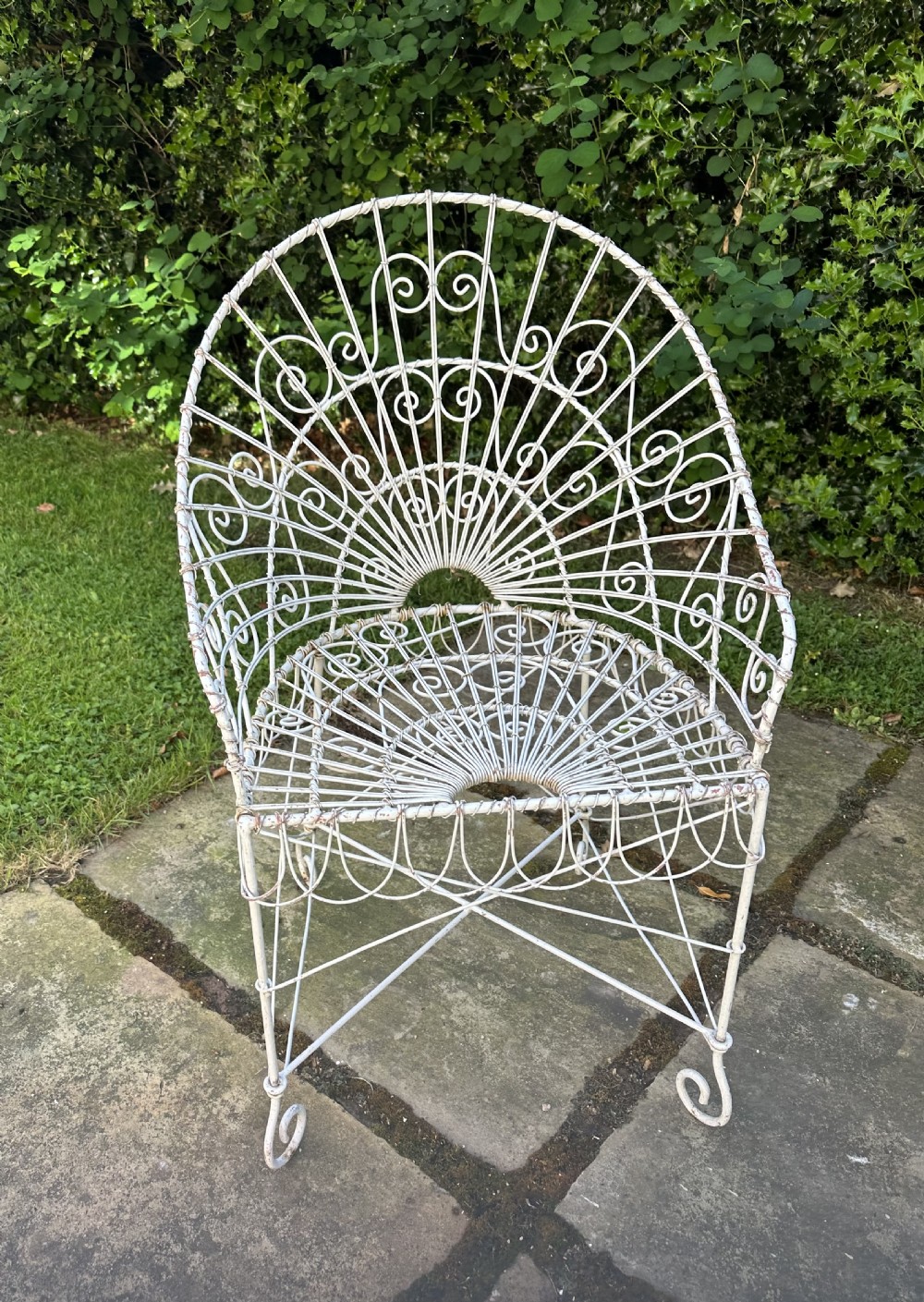 A three-piece white painted wrought iron wirework garden set featuring a bench and two matching armchairs with arched fan-back designs. View VI
