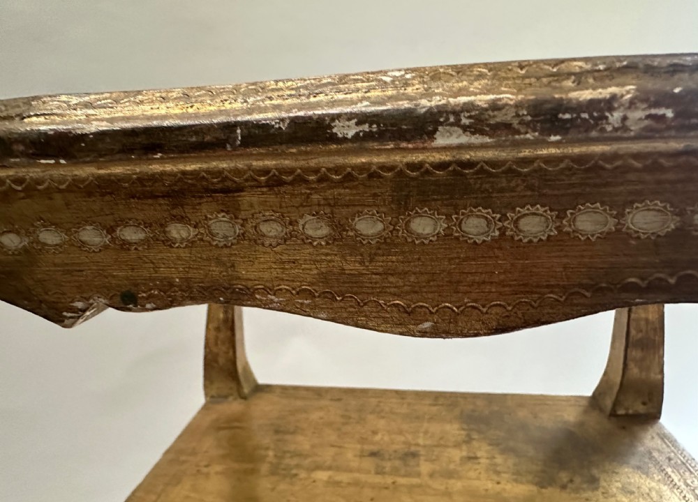 A two-tiered Italian Florentine side table with a distressed gold leaf finish, cabriole legs, a scalloped apron, and decorative top surface detailing. View VI