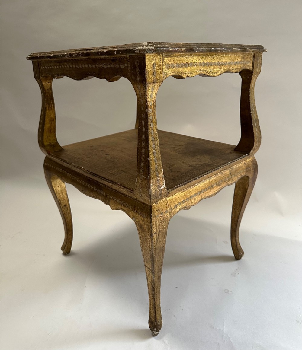 A two-tiered Italian Florentine side table with a distressed gold leaf finish, cabriole legs, a scalloped apron, and decorative top surface detailing. View VII
