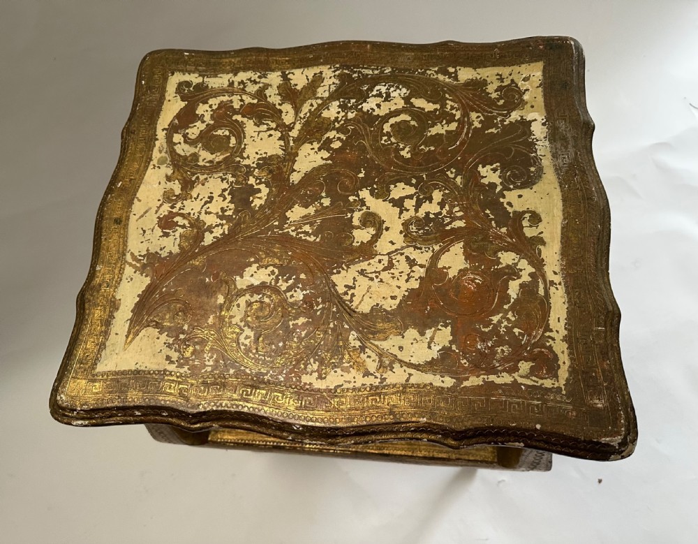 A two-tiered Italian Florentine side table with a distressed gold leaf finish, cabriole legs, a scalloped apron, and decorative top surface detailing. View VIII