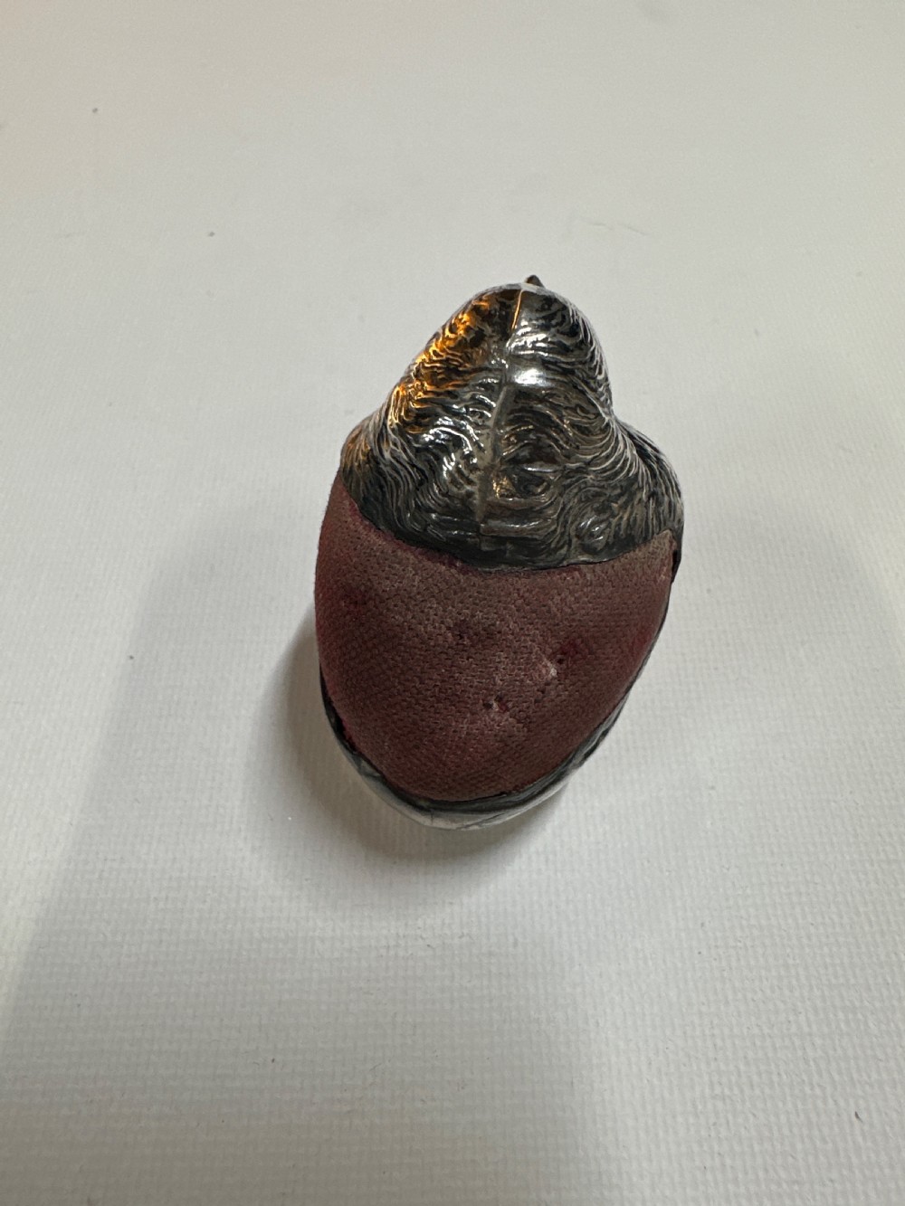An Edwardian sterling silver novelty pin cushion modelled in the form of a chick hatching from an egg with a dark red velvet insert. View III