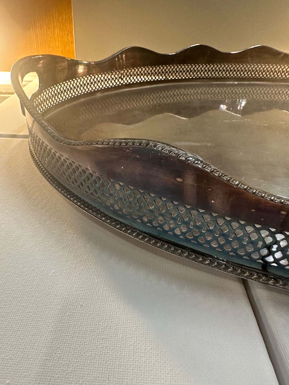 An oval silver-plated serving tray with a pierced reticulated gallery rim, scalloped border, and integrated side handles. View II