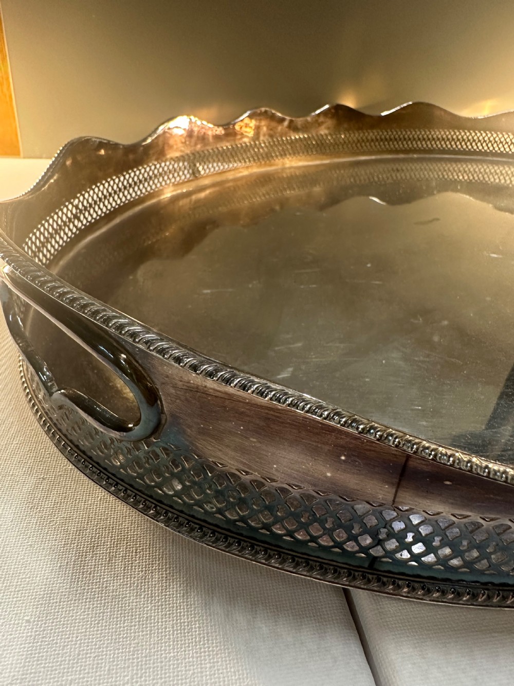 An oval silver-plated serving tray with a pierced reticulated gallery rim, scalloped border, and integrated side handles. View VIII