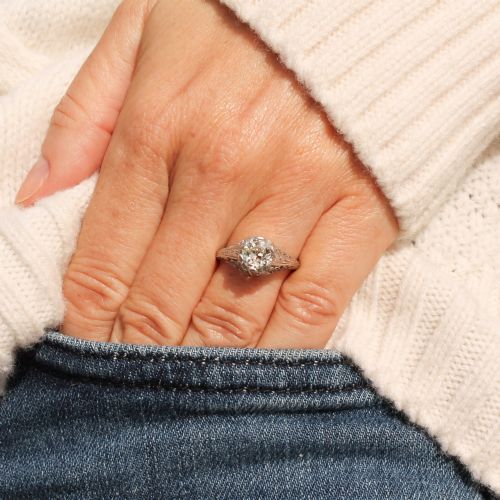 fig 1. An Art Deco solitaire ring featuring an old European cut diamond set in an intricately carved filigree silver-coloured band.