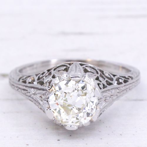 fig 2. An Art Deco solitaire ring featuring an old European cut diamond set in an intricately carved filigree silver-coloured band.