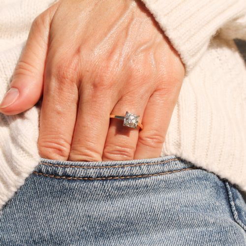 fig 1. A vintage solitaire engagement ring featuring an old cut cushion diamond held in platinum claws on a tapered yellow gold band.