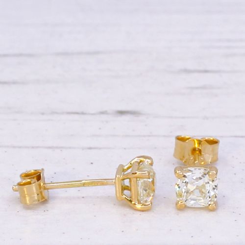 A pair of 18k yellow gold stud earrings featuring claw-set old mine cut cushion diamonds. View IV
