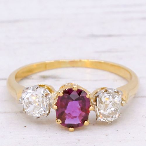 fig 2. An antique yellow gold trilogy ring featuring a central cushion-cut red ruby flanked by two old-cut diamonds in claw settings.