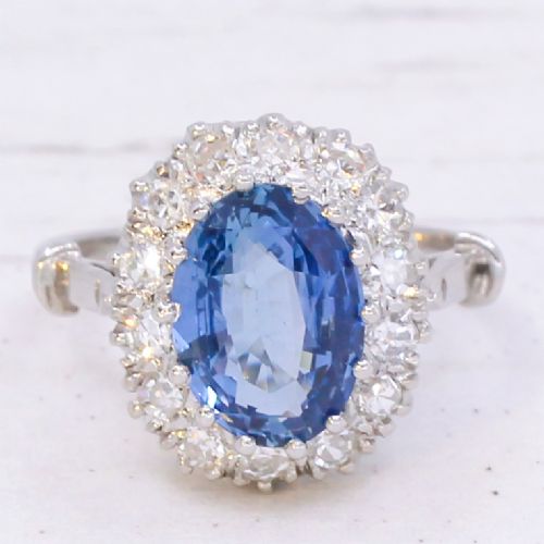 fig 2. An oval blue Ceylon sapphire encircled by a halo of brilliant diamonds set on a silver metal band.